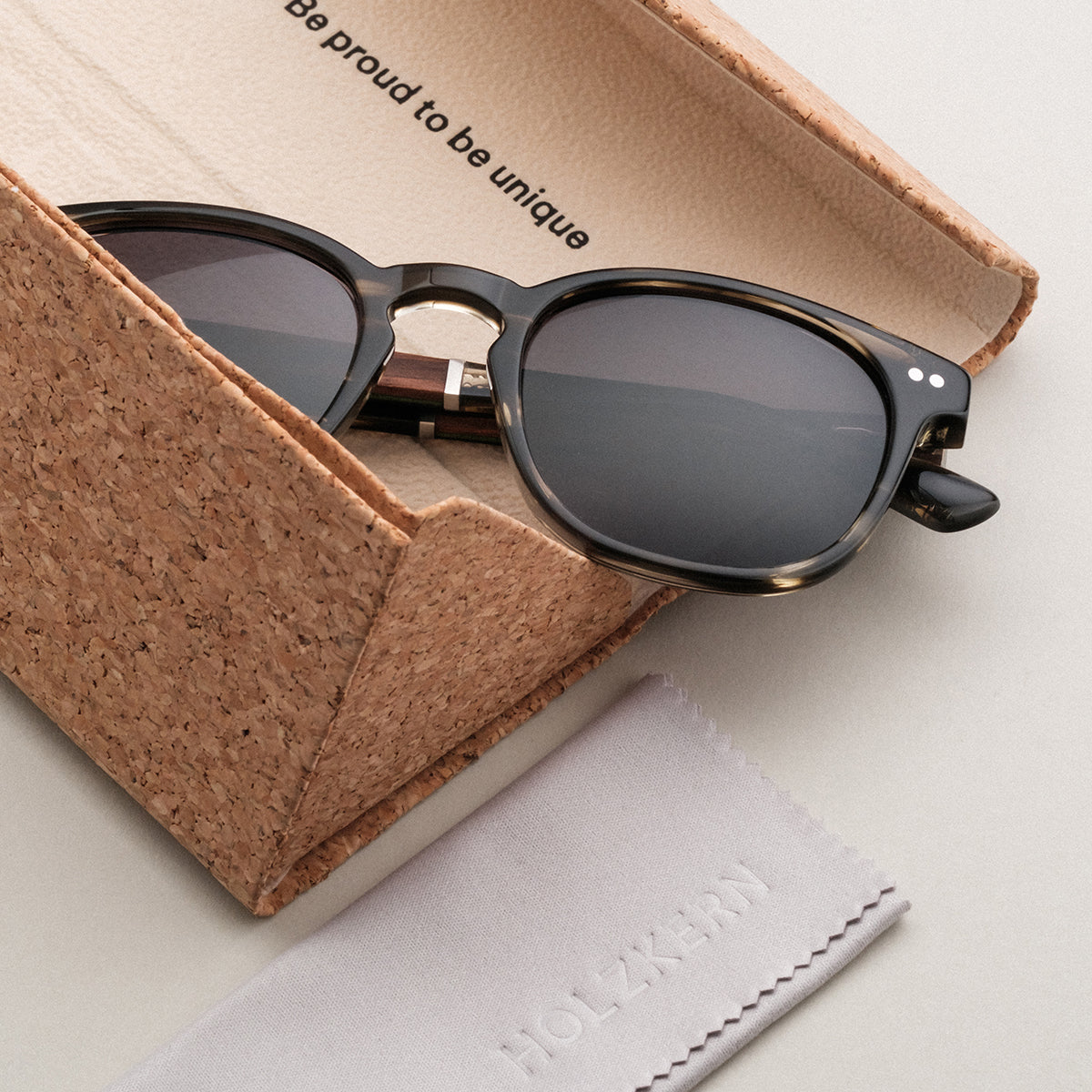 "The Comedian" sunglasses in Leadwood/Khaki Dust style, featuring a sleek, modern design with a unique cork case.