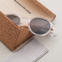 "The Hyped" sunglasses with a crystal frame and zebrawood accents, showcased in an elegant cork case.