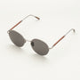 "The Adventurous" sunglasses, featuring a walnut wood and dark gray style, with round lenses in a sleek design.