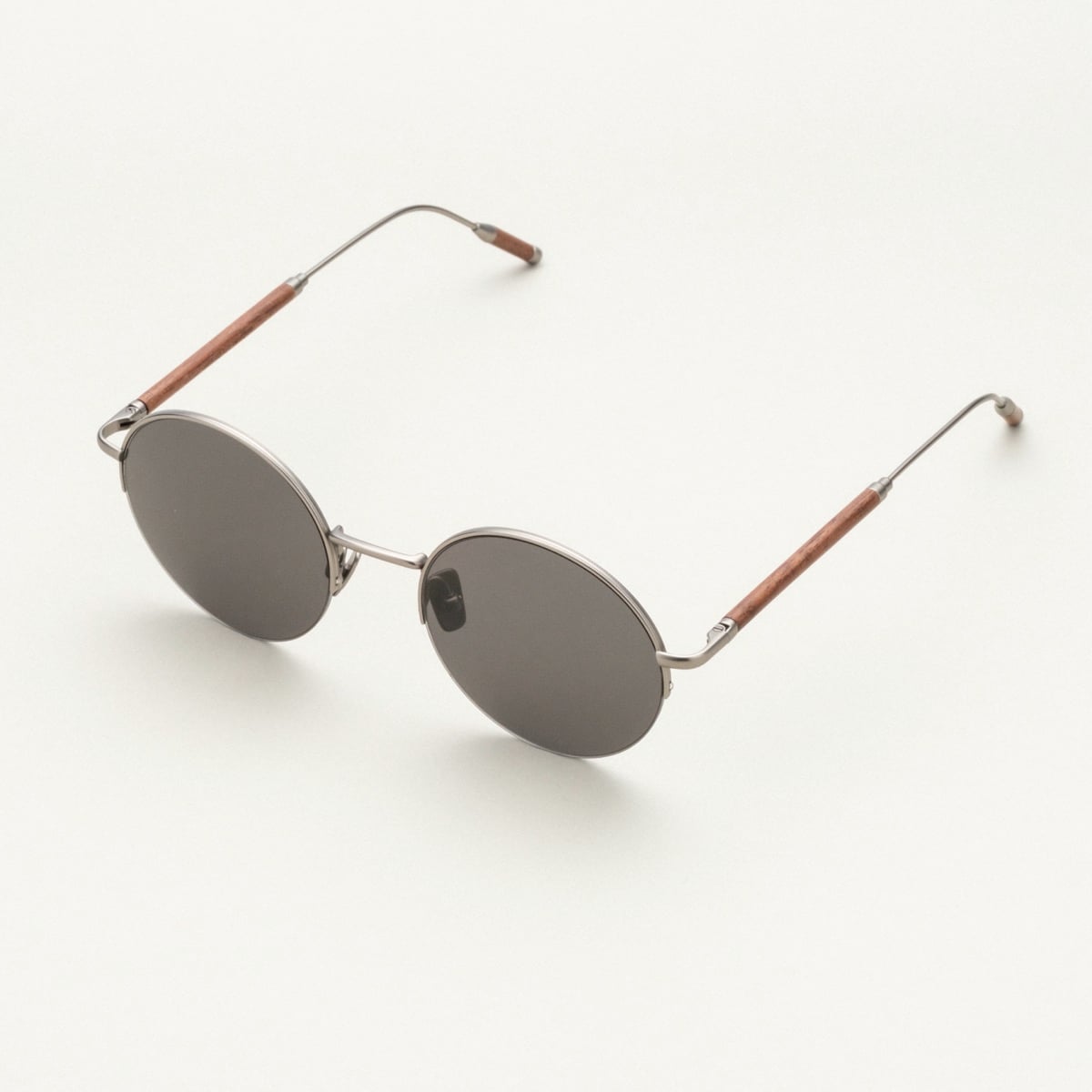 "The Adventurous" sunglasses, featuring a walnut wood and dark gray style, with round lenses in a sleek design.
