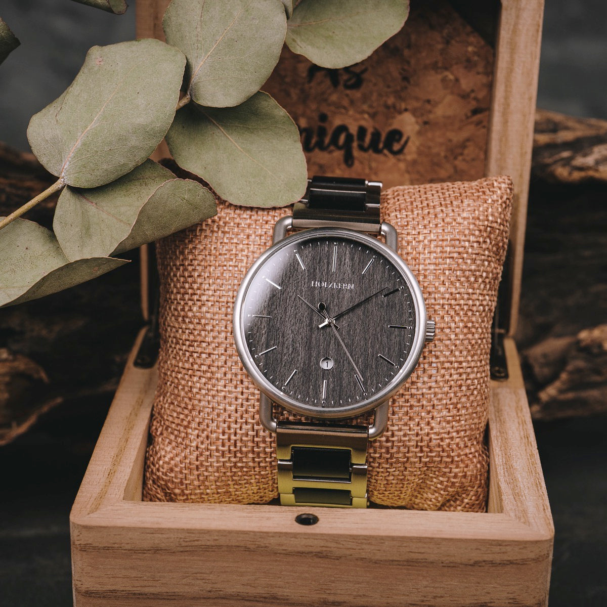 "Odaiba" watch in a wooden box, featuring a sleek dark face with a minimalist design and metallic accents.