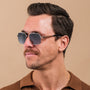 "The Professor", stylish sunglasses with walnut frames and antique silver accents, worn by a man against a neutral background.