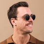 "The Radiant M" sunglasses in walnut and antique silver, featuring a sleek, round design for a sophisticated look.