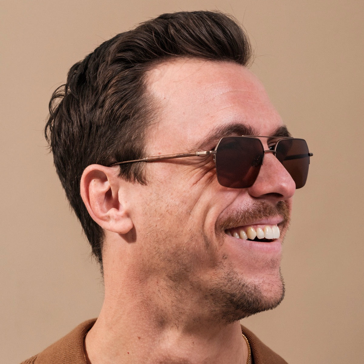 "The Visionary" sunglasses, featuring a sophisticated walnut and bronze design.