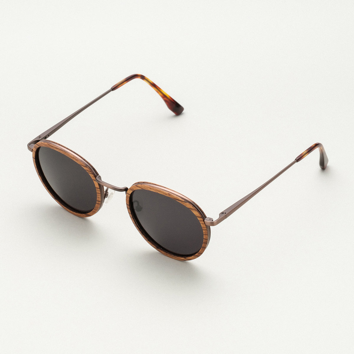"The Loving" sunglasses feature a zebrawood frame with antique copper accents and round lenses for a stylish, classic look.