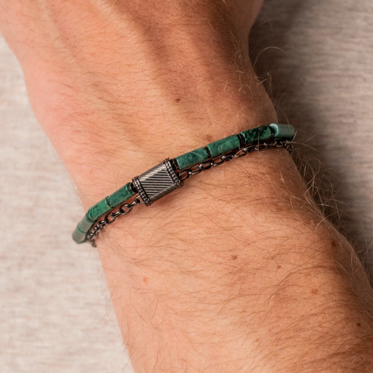 "Supersonic" bracelet featuring aventurine beads and gray accents, worn elegantly on a wrist.