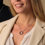 "Inseparable S" necklace featuring a walnut and silver design, elegantly showcased on a model wearing a light blazer.
