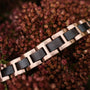 "Acoustic", a bracelet featuring a stylish maple and rose gold design, set against a floral background.