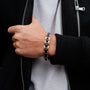 "Acoustic", a stylish bracelet featuring maple and rose gold tones, worn with a black jacket.
