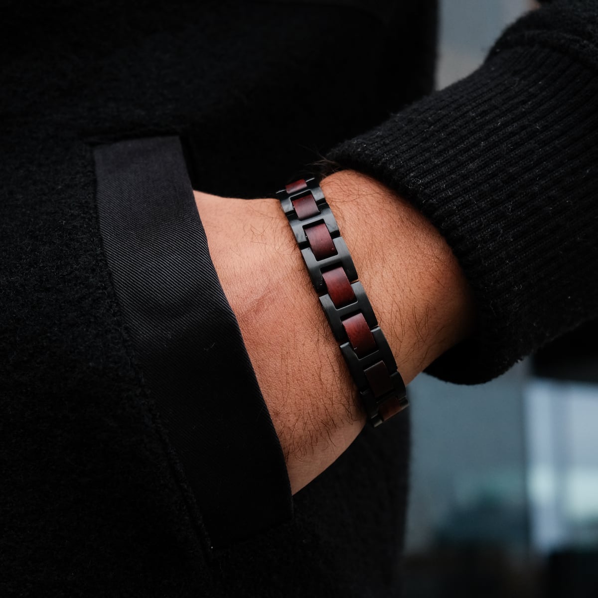"Acoustic" bracelet featuring a sleek padauk and black design, worn on a wrist for a stylish look.