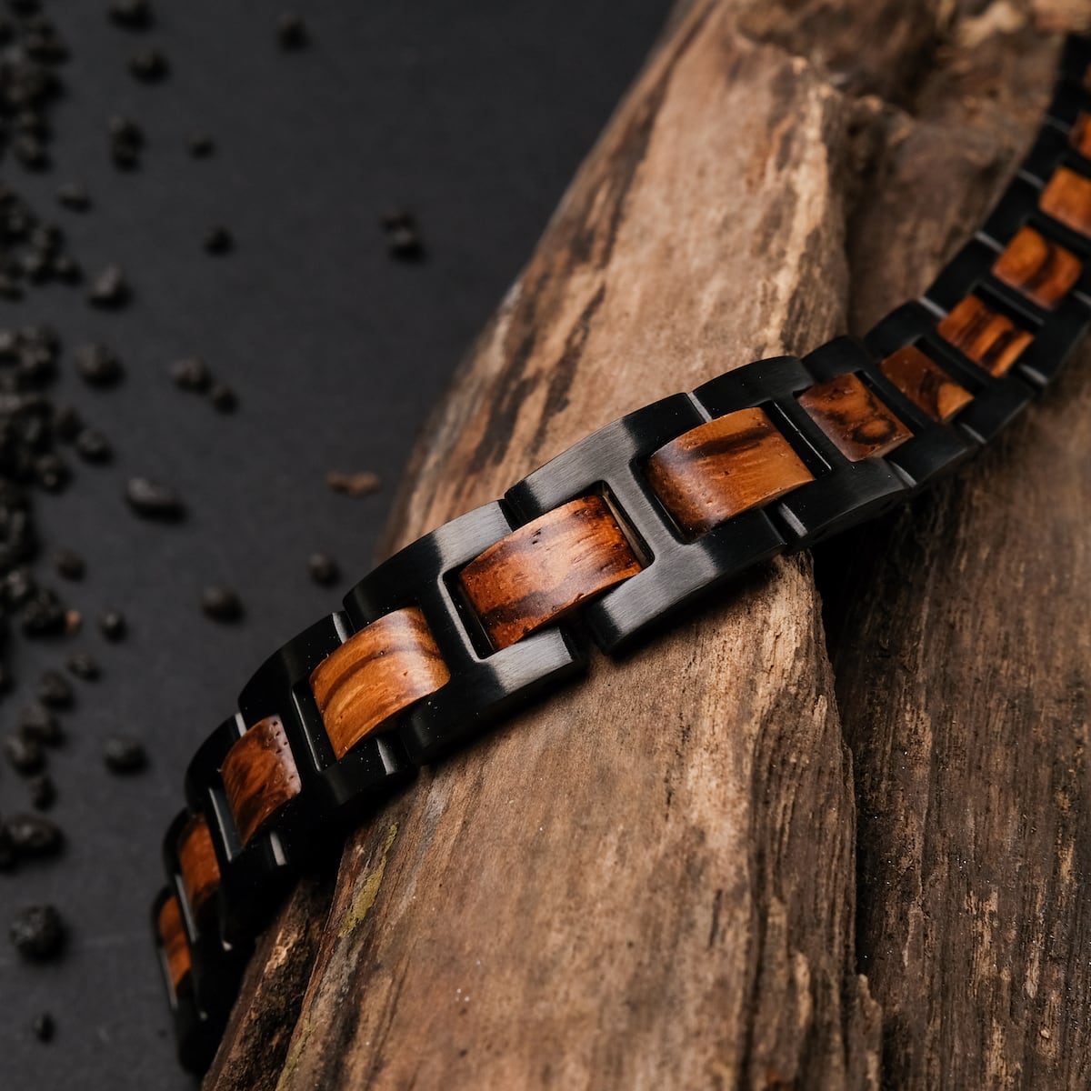 "Acoustic", a stylish bracelet featuring zebrawood and black materials, elegantly displayed on a rustic wooden surface.