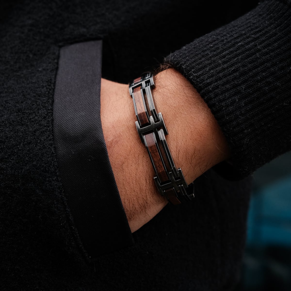 "Staccato", a stylish bracelet featuring walnut and antique silver elements, displayed on a wrist.