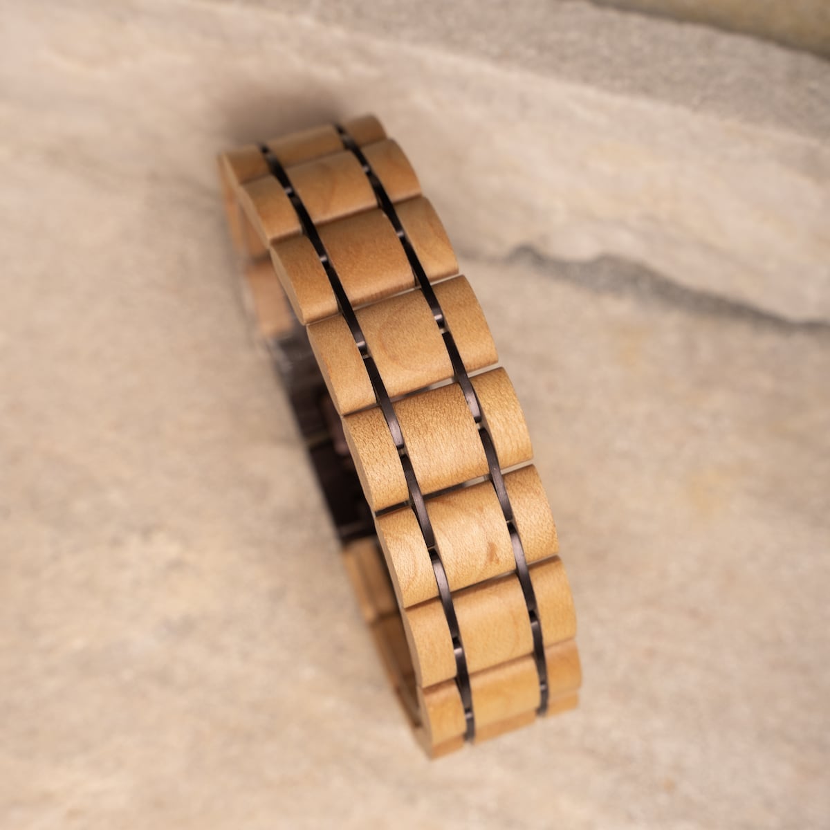 "Grandezza" bracelet, featuring maple and dark purple materials in a sleek, modern design.