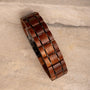 "Grandezza wristband, featuring mahogany and gray tones in a sleek, geometric design."