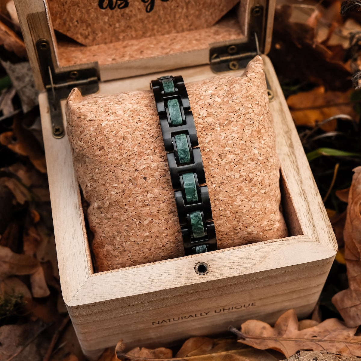 "Forte" bracelet in marble and black, showcased in a rustic wooden box with a natural setting.