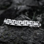 "Forte" bracelet in a marble and silver design, showcasing a sleek and modern style on a rugged rock background.