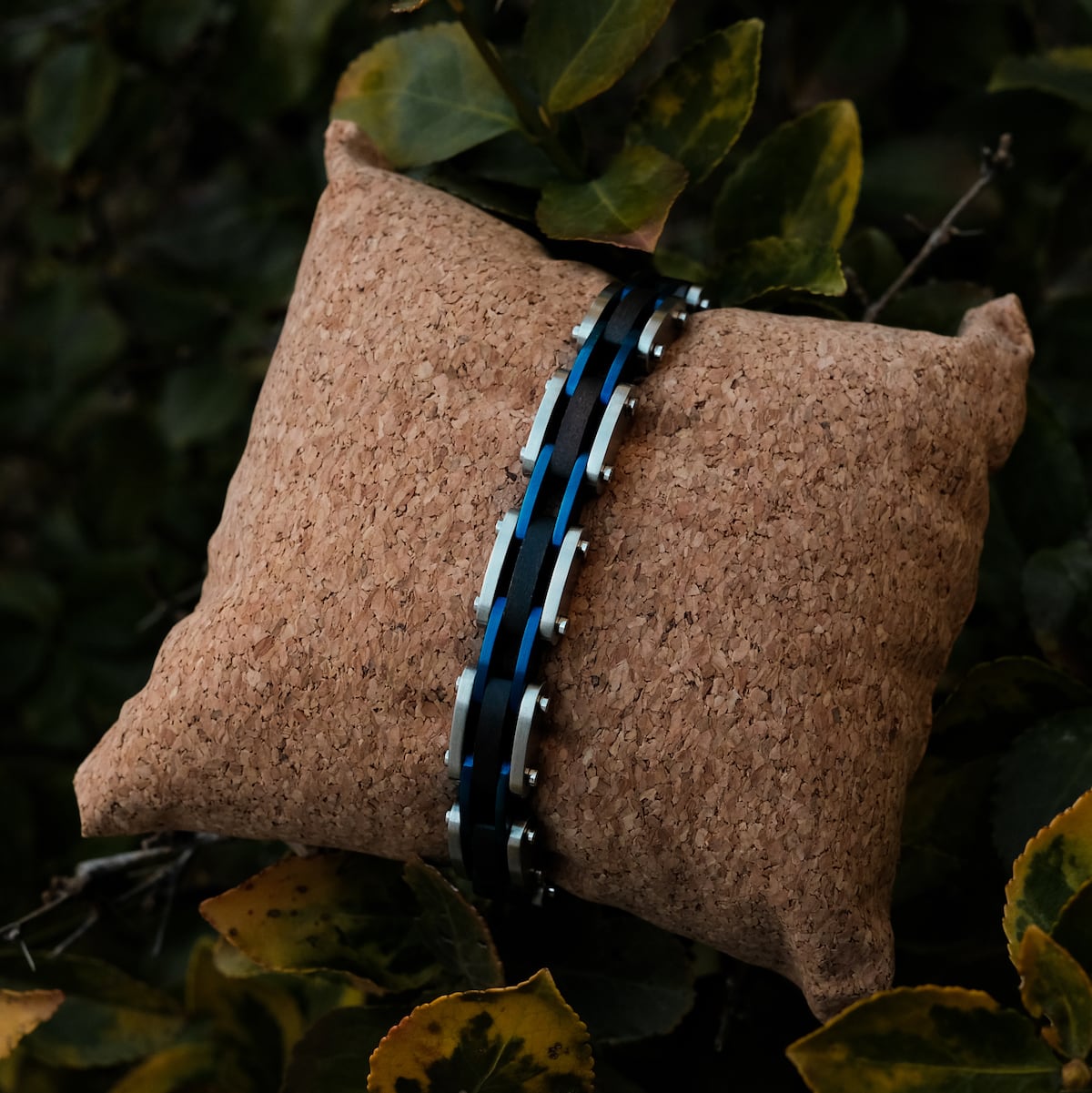 "Allegro" bracelet featuring a sleek maple and silver design on a textured cushion.