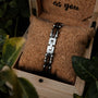 "Allegro" Bracelet featuring Walnut and Silver materials, presented on a cork cushion in a rustic wooden box.