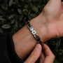 "Allegro" bracelet featuring walnut and silver materials with a modern, elegant design.