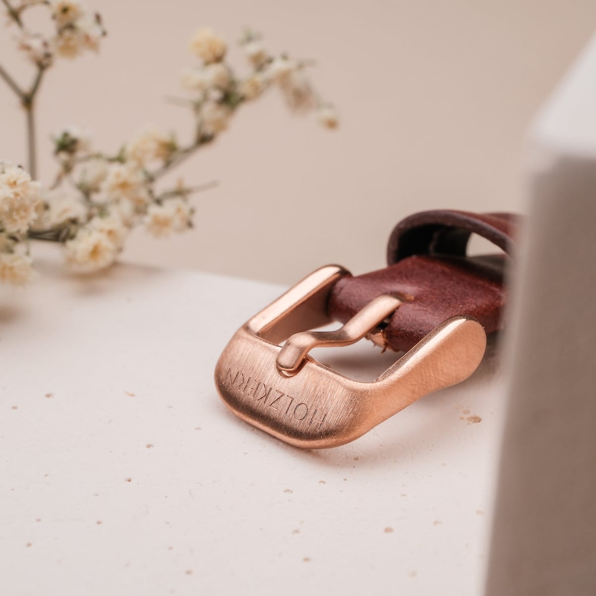 "Harriet" belt buckle in rose gold with a walnut and maple finish, featuring a sophisticated and elegant design.