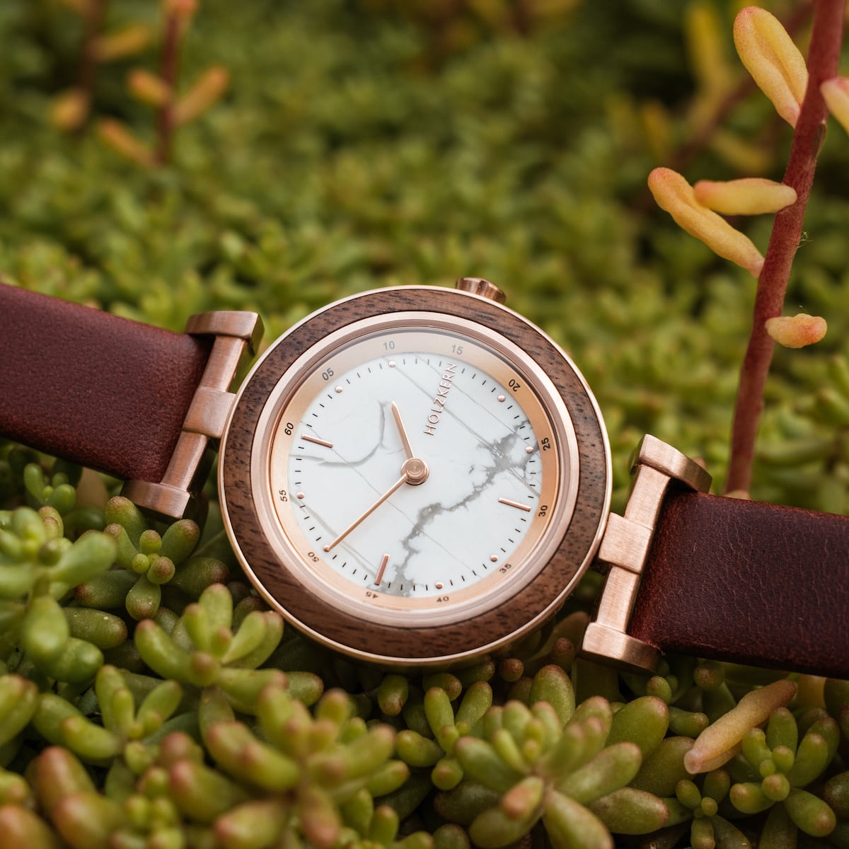 "Ida" watch with a walnut frame and marble dial, featuring a sleek, elegant design on a brown leather strap.