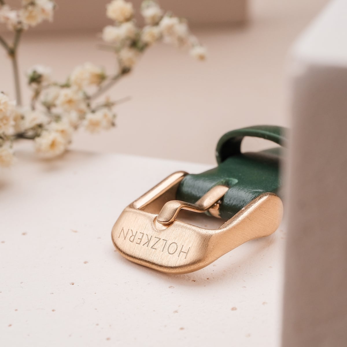 "Laura", a stylish belt with a green leather strap and gold buckle, exuding elegance and sophistication.