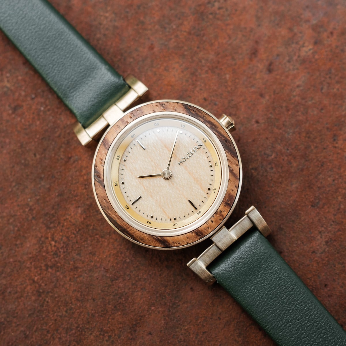 "Laura" watch, featuring a zebrawood and oak design with a green leather strap, showcasing a modern and elegant style.