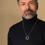 "Inseparable L", a stylish walnut and silver necklace, worn on a person in a dark turtleneck.