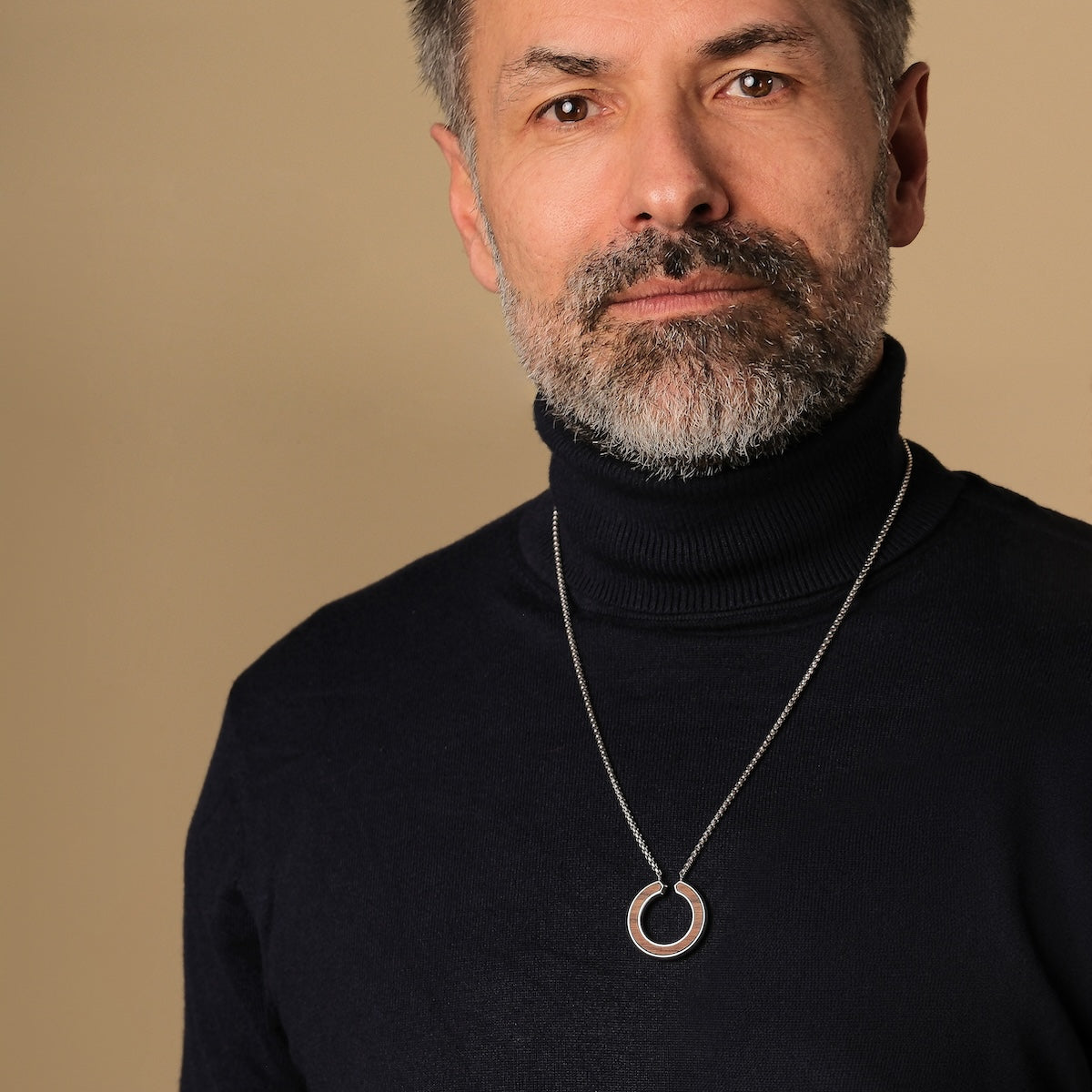 "Inseparable L", a stylish walnut and silver necklace, worn on a person in a dark turtleneck.