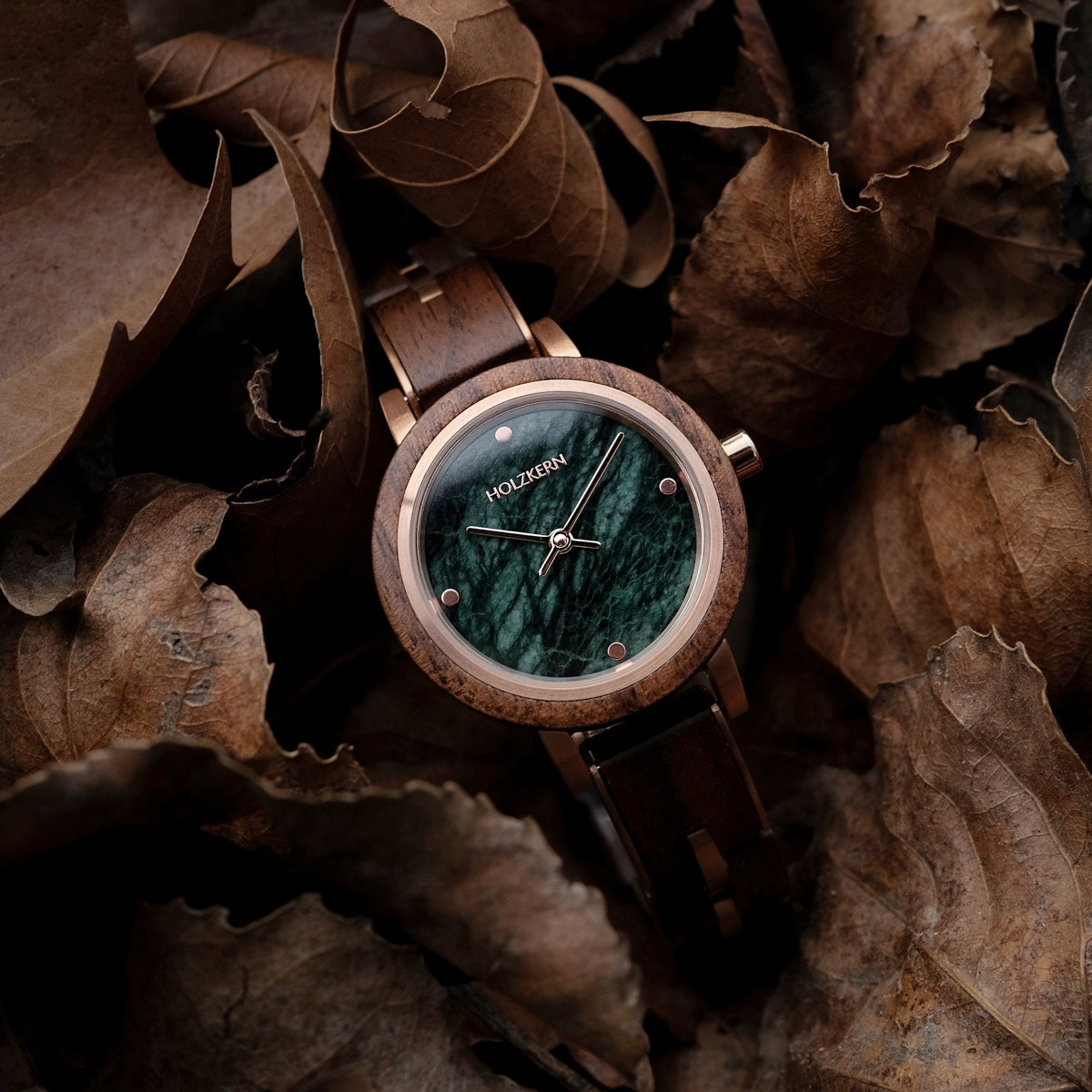 "Euterpe" watch featuring a walnut wood case and green marble dial, surrounded by autumn leaves.