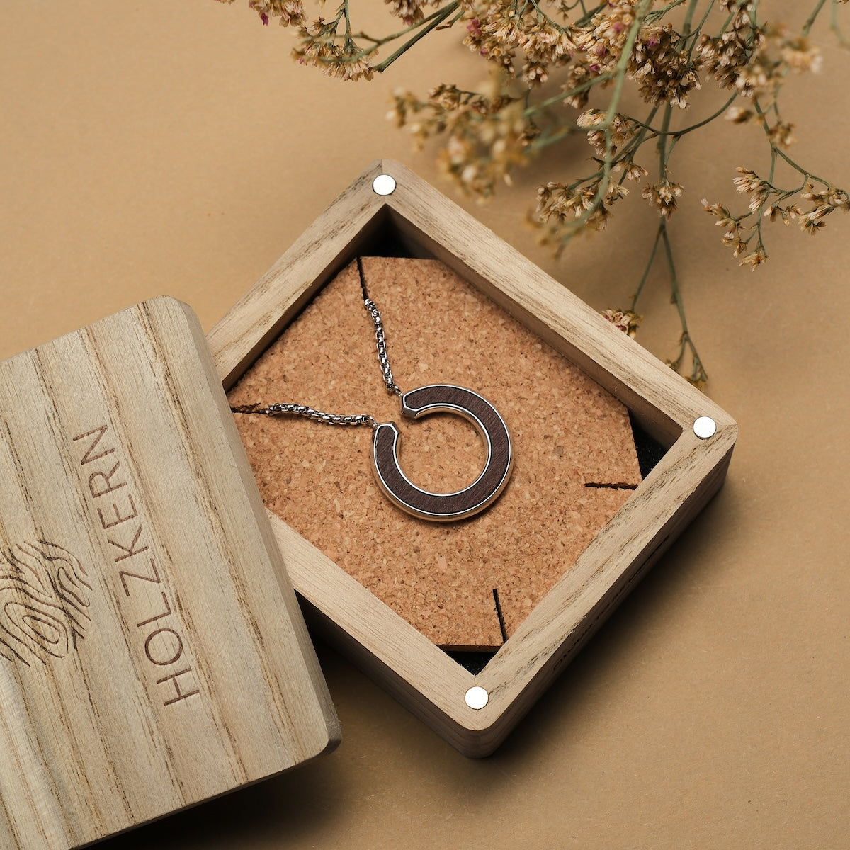 "Inseparable S" necklace with a walnut and silver finish, displayed in an elegant wooden box.