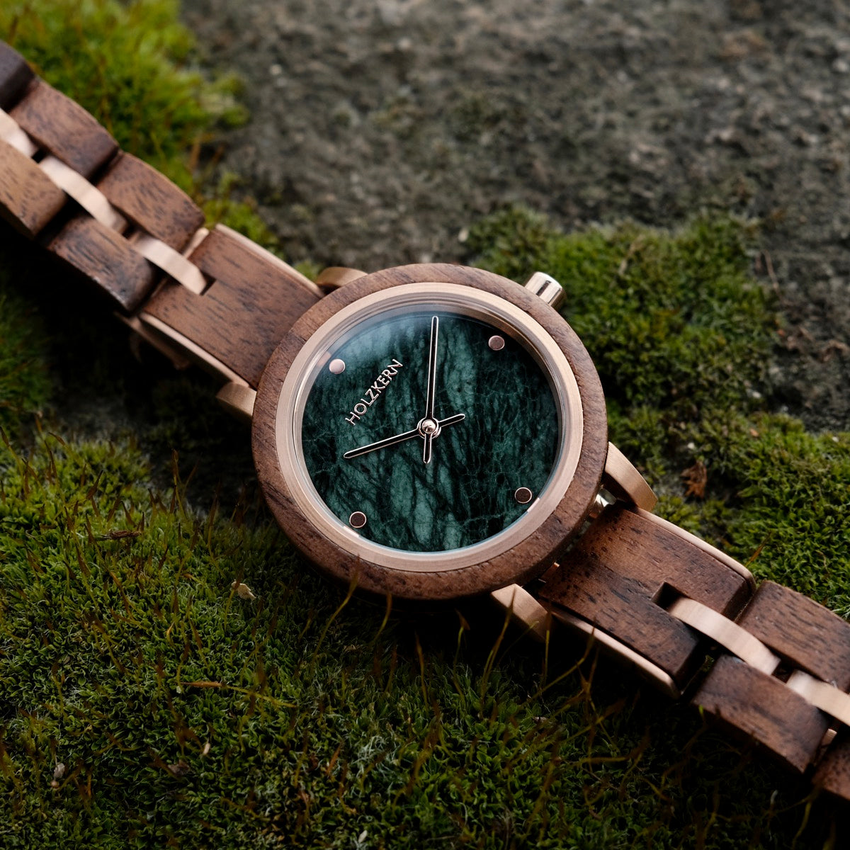 Euterpe watch with a Walnut band and marble face on a mossy background.