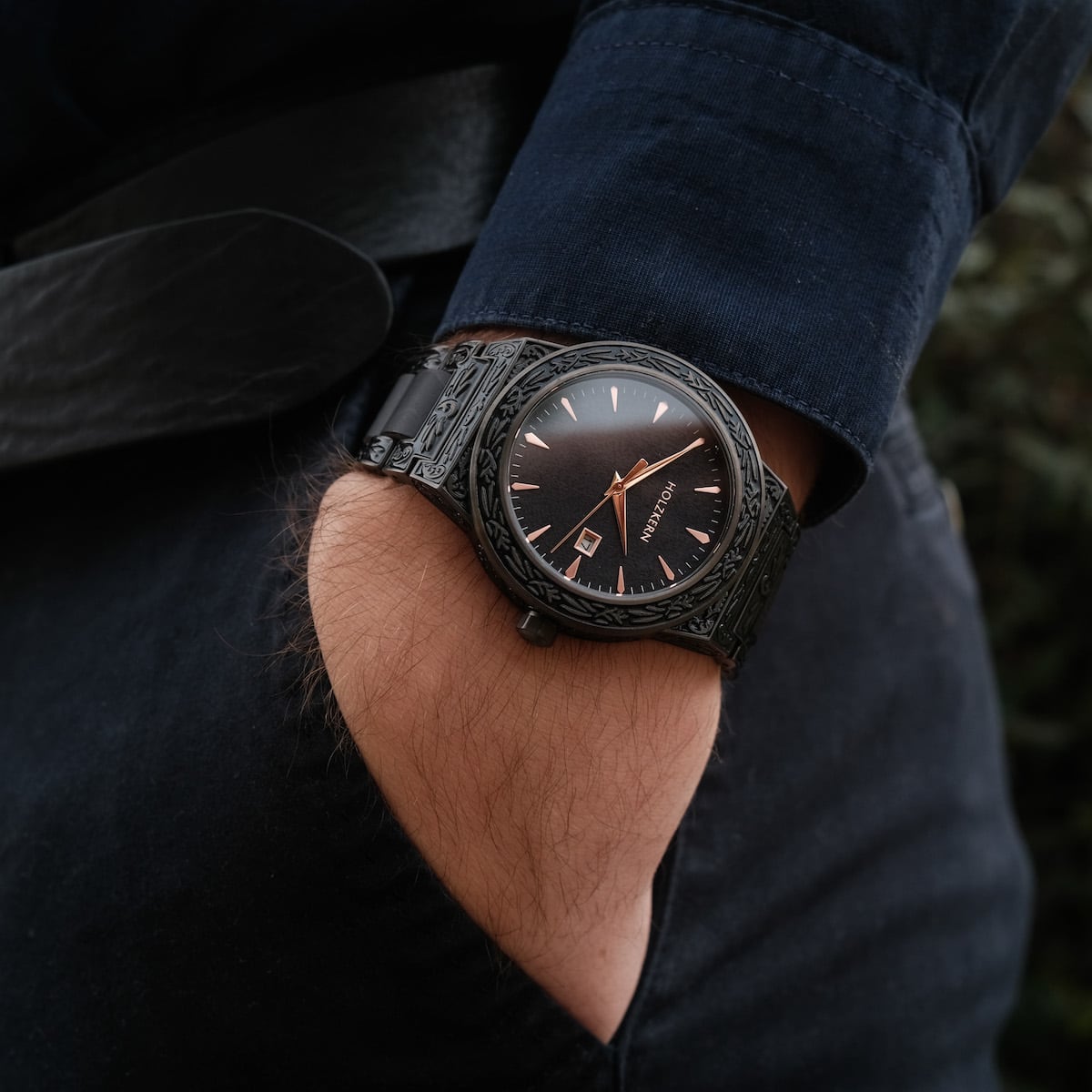 "Khalili" watch featuring a sleek, all-black design and intricate detailing, worn with a casual outfit.